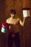 De gebaarde spiermens met sexy lichaam houdt rood doos toenam royalty-vrije stock afbeelding De gebaarde spiermens met sexy lichaam houdt rood doos toenam royalty-vrije stock afbeelding