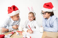 De gelukkige leuke kinderen maken Kerstmisgroeten royalty-vrije stock fotografie De gelukkige leuke kinderen maken Kerstmisgroeten royalty-vrije stock fotografie