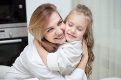 De gelukkige Moeder en de dochter koesteren thuis stock afbeeldingen De gelukkige Moeder en de dochter koesteren thuis stock afbeeldingen