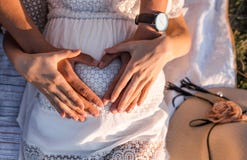De gelukkige ouders houden de zwangere buik royalty-vrije stock afbeelding De gelukkige ouders houden de zwangere buik royalty-vrije stock afbeelding