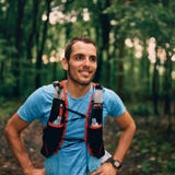 De geschikte mannelijke joggerrust tijdens dagjogging voor de dwars bossleep van het land rent in een aardpark stock fotografie De geschikte mannelijke joggerrust tijdens dagjogging voor de dwars bossleep van het land rent in een aardpark stock fotografie