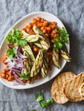 De gesmoorde kekers in tomatensaus, geroosterde aubergine en courgette, roosterden brood - een heerlijke voorgerecht of een snack stock afbeeldingen De gesmoorde kekers in tomatensaus, geroosterde aubergine en courgette, roosterden brood - een heerlijke voorgerecht of een snack stock afbeeldingen
