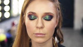 De gezichtmeester maakt laatste aanrakingen want de ogen een mooi model met kameleonogen maken omhoog effect goedmaken Front View stock video De gezichtmeester maakt laatste aanrakingen want de ogen een mooi model met kameleonogen maken omhoog effect goedmaken Front View stock video