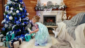 De giften onder de Kerstboom op Kerstavondochtend, het meisje neemt een verrassing van het gift blije Nieuwjaar ` s, een gelukkig stock videobeelden De giften onder de Kerstboom op Kerstavondochtend, het meisje neemt een verrassing van het gift blije Nieuwjaar ` s, een gelukkig stock videobeelden