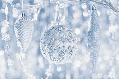 De glanzende zilveren Kerstmisornamenten die op een boom, hangen met defocused Kerstmislichten op de achtergrond De achtergrond v royalty-vrije stock afbeelding De glanzende zilveren Kerstmisornamenten die op een boom, hangen met defocused Kerstmislichten op de achtergrond De achtergrond v royalty-vrije stock afbeelding