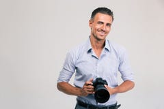De glimlachende camera van de fotograafholding royalty-vrije stock foto De glimlachende camera van de fotograafholding royalty-vrije stock foto