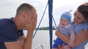 De goede stemming van vriendschappelijke familie op vakantie aan rivier, jonge mamma en papa speelde met baby op overzees in boot stock videobeelden De goede stemming van vriendschappelijke familie op vakantie aan rivier, jonge mamma en papa speelde met baby op overzees in boot stock videobeelden