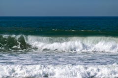 De golven die van de Atlantische Oceaan op de overzeese kust breken stock afbeelding De golven die van de Atlantische Oceaan op de overzeese kust breken stock afbeelding