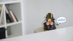 De grappige Robot zegt HELLO Experiment met Intelligente Manipulator Industrieel Robotmodel met Grappig Gezicht De grappige Robot zegt HELLO Experiment met Intelligente Manipulator Industrieel Robotmodel met Grappig Gezicht