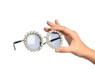 De greep moderne ronde die zonnebril van de vrouwenhand met parel op een wit wordt geïsoleerd stock foto's De greep moderne ronde die zonnebril van de vrouwenhand met parel op een wit wordt geïsoleerd stock foto's