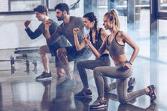 De groep atletische jongeren in sportkleding het doen valt oefening bij de gymnastiek uit stock afbeeldingen De groep atletische jongeren in sportkleding het doen valt oefening bij de gymnastiek uit stock afbeeldingen