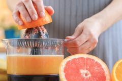 De handen van de vrouw houdt een oranje half en het maken sap royalty-vrije stock afbeeldingen De handen van de vrouw houdt een oranje half en het maken sap royalty-vrije stock afbeeldingen