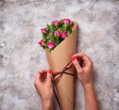 De handen van vrouwen verpakken een boeket van rozen in document royalty-vrije stock fotografie De handen van vrouwen verpakken een boeket van rozen in document royalty-vrije stock fotografie