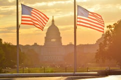De het Capitoolbouw van Verenigde Staten en de vlagsilhouet van de V.S. bij zonsopgang, Washington DC stock afbeelding De het Capitoolbouw van Verenigde Staten en de vlagsilhouet van de V.S. bij zonsopgang, Washington DC stock afbeelding