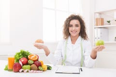 De holdingsfruit en croissant van de vrouwenvoedingsdeskundige in handen stock fotografie De holdingsfruit en croissant van de vrouwenvoedingsdeskundige in handen stock fotografie