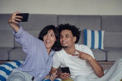 De jeunes couples de sourire prenant des selfies dans le lit utilisant un smartphone, ils se couchent et pose images libres de droits De jeunes couples de sourire prenant des selfies dans le lit utilisant un smartphone, ils se couchent et pose images libres de droits