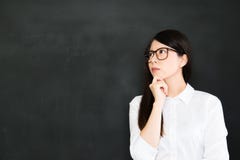 De jonge Aziatische leraar denkt over opeenhoping een goed onderwijs stock afbeelding De jonge Aziatische leraar denkt over opeenhoping een goed onderwijs stock afbeelding
