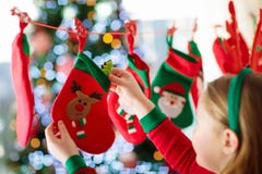 De jonge geitjes die Kerstmis openen stelt voor Kind die naar suikergoed en giften in komstkalender zoeken op de winterochtend Ve royalty-vrije stock foto's De jonge geitjes die Kerstmis openen stelt voor Kind die naar suikergoed en giften in komstkalender zoeken op de winterochtend Ve royalty-vrije stock foto's