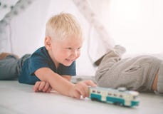 De jonge geitjesbroers leggen op de vloer De jongens spelen in huis met stuk speelgoed auto's thuis in de ochtend Toevallige leve royalty-vrije stock foto's De jonge geitjesbroers leggen op de vloer De jongens spelen in huis met stuk speelgoed auto's thuis in de ochtend Toevallige leve royalty-vrije stock foto's
