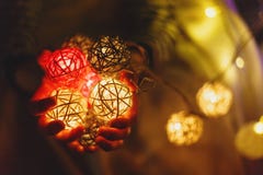 De jonge geitjeshanden houden een balslinger voor Kerstmis of Nieuw jaar thuis op lichtenachtergrond Nieuwe jaar en Kerstmisvieri stock foto's De jonge geitjeshanden houden een balslinger voor Kerstmis of Nieuw jaar thuis op lichtenachtergrond Nieuwe jaar en Kerstmisvieri stock foto's