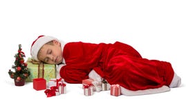 De jonge jongen in feestelijk die Nieuwjaar` s kostuum viel in slaap op doos met gift, op wit wordt geïsoleerd stock foto's De jonge jongen in feestelijk die Nieuwjaar` s kostuum viel in slaap op doos met gift, op wit wordt geïsoleerd stock foto's
