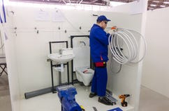 De jonge loodgieter installeert materiaal voor badkamers stock afbeelding De jonge loodgieter installeert materiaal voor badkamers stock afbeelding