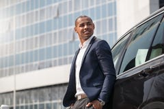 De jonge mens die zich dichtbij auto bevinden dient zakken in kijkend opzij peinzend zijaanzicht royalty-vrije stock foto De jonge mens die zich dichtbij auto bevinden dient zakken in kijkend opzij peinzend zijaanzicht royalty-vrije stock foto