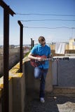 De jonge mens speelt elektrische gitaar op dakterras royalty-vrije stock fotografie De jonge mens speelt elektrische gitaar op dakterras royalty-vrije stock fotografie