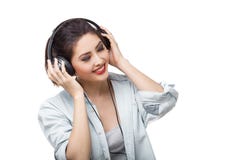 De jonge mooie vrouw geniet van luister aan muziek met grote hoofdtelefoons isoleerde witte achtergrond royalty-vrije stock fotografie De jonge mooie vrouw geniet van luister aan muziek met grote hoofdtelefoons isoleerde witte achtergrond royalty-vrije stock fotografie