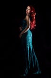 De jonge roodharige sexy vrouw in blauwe elegante kleding stelt in dark stock afbeeldingen De jonge roodharige sexy vrouw in blauwe elegante kleding stelt in dark stock afbeeldingen