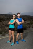 De jonge stellende schouder die van het sportpaar aan schouder koele en uitdagende houding kijken stock foto De jonge stellende schouder die van het sportpaar aan schouder koele en uitdagende houding kijken stock foto
