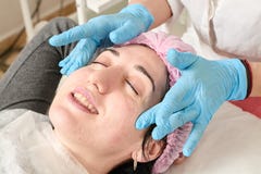De jonge vrouw doet professionele gezichtsmassage in de schoonheidssalon stock afbeeldingen De jonge vrouw doet professionele gezichtsmassage in de schoonheidssalon stock afbeeldingen