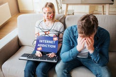 De jonge vrouw heeft sociale media verslaving Het zitten op gevoelloze bank Lichaam met koord wordt verpakt dat Handen op toetsen royalty-vrije stock fotografie De jonge vrouw heeft sociale media verslaving Het zitten op gevoelloze bank Lichaam met koord wordt verpakt dat Handen op toetsen royalty-vrije stock fotografie
