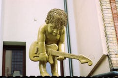 De jongen speelt een gitaarstandbeeld royalty-vrije stock afbeeldingen De jongen speelt een gitaarstandbeeld royalty-vrije stock afbeeldingen