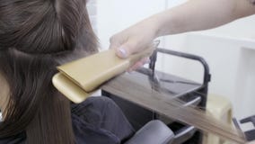 De kapper maakt haarlaminering in een schoonheidssalon voor een meisje met donkerbruin haar stock videobeelden De kapper maakt haarlaminering in een schoonheidssalon voor een meisje met donkerbruin haar stock videobeelden