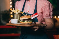 De kelner draagt een hamburger stock afbeelding De kelner draagt een hamburger stock afbeelding