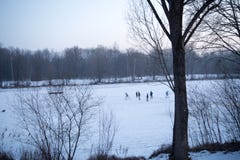 De kinderen spelen ijshockey op een bevroren meer royalty-vrije stock afbeelding De kinderen spelen ijshockey op een bevroren meer royalty-vrije stock afbeelding