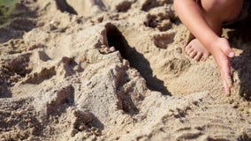 De kindspelen met zand op de zomerstrand stock videobeelden De kindspelen met zand op de zomerstrand stock videobeelden