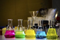 De kleurrijke oplossing in kegelfles voerde op een bank in een chemielaboratorium met onduidelijk beeld achtergrond organisch che royalty-vrije stock afbeelding De kleurrijke oplossing in kegelfles voerde op een bank in een chemielaboratorium met onduidelijk beeld achtergrond organisch che royalty-vrije stock afbeelding