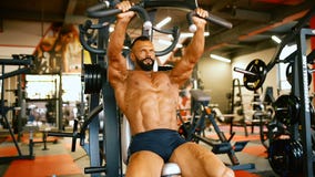 De knappe atleet oefent in gymnastiekcentrum uit Bodybuildermens harde opleidingsspieren bij opleidingsmachine stock videobeelden De knappe atleet oefent in gymnastiekcentrum uit Bodybuildermens harde opleidingsspieren bij opleidingsmachine stock videobeelden