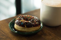 De koffie met een getrokken hart en de melk op een houten lijst in een koffie winkelen royalty-vrije stock afbeeldingen De koffie met een getrokken hart en de melk op een houten lijst in een koffie winkelen royalty-vrije stock afbeeldingen
