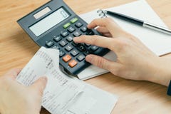De kosten en de betalingsconcept van de van de uitgavenberekening of rekening, hand zetten vinger op calculator en zwarte pen op stock foto's De kosten en de betalingsconcept van de van de uitgavenberekening of rekening, hand zetten vinger op calculator en zwarte pen op stock foto's