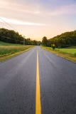 De lange weg van het land met gele lijnen onderaan het centrum royalty-vrije stock foto De lange weg van het land met gele lijnen onderaan het centrum royalty-vrije stock foto