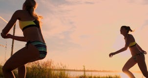 DE LANGZAME MOTIE, LAGE HOEK, SLUIT OMHOOG, ZONgloed: Het atletische volleyball van het meisjes speelstrand springt in de lucht e stock video DE LANGZAME MOTIE, LAGE HOEK, SLUIT OMHOOG, ZONgloed: Het atletische volleyball van het meisjes speelstrand springt in de lucht e stock video