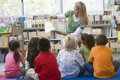 De leraar die van de kleuterschool aan kinderen leest stock foto's De leraar die van de kleuterschool aan kinderen leest stock foto's