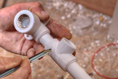 De loodgieter maakt tekens op de plastic montage gebruikend een potlood stock foto's De loodgieter maakt tekens op de plastic montage gebruikend een potlood stock foto's