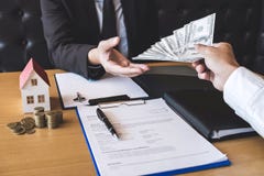 De makelaar van de landgoedagent ontvangt geld van cliënt na het ondertekenen van onroerende goederen overeenkomstencontract met stock afbeelding De makelaar van de landgoedagent ontvangt geld van cliënt na het ondertekenen van onroerende goederen overeenkomstencontract met stock afbeelding