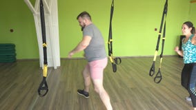 De meisjes en de mensen van groepsklassen met een trainer zijn bezet op de TRX-lijnen, gewichtsverlies en de ontwikkeling van duu stock video De meisjes en de mensen van groepsklassen met een trainer zijn bezet op de TRX-lijnen, gewichtsverlies en de ontwikkeling van duu stock video