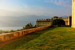 De mening van Nice van de bergen en het meer van het oude kasteel in de avond wanneer de zon daalt Italië, Angera Kasteel Rocca royalty-vrije stock foto's De mening van Nice van de bergen en het meer van het oude kasteel in de avond wanneer de zon daalt Italië, Angera Kasteel Rocca royalty-vrije stock foto's