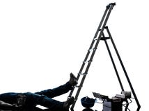 De mens die van de ongevallen handarbeider van laddersilhouet vallen royalty-vrije stock afbeelding De mens die van de ongevallen handarbeider van laddersilhouet vallen royalty-vrije stock afbeelding